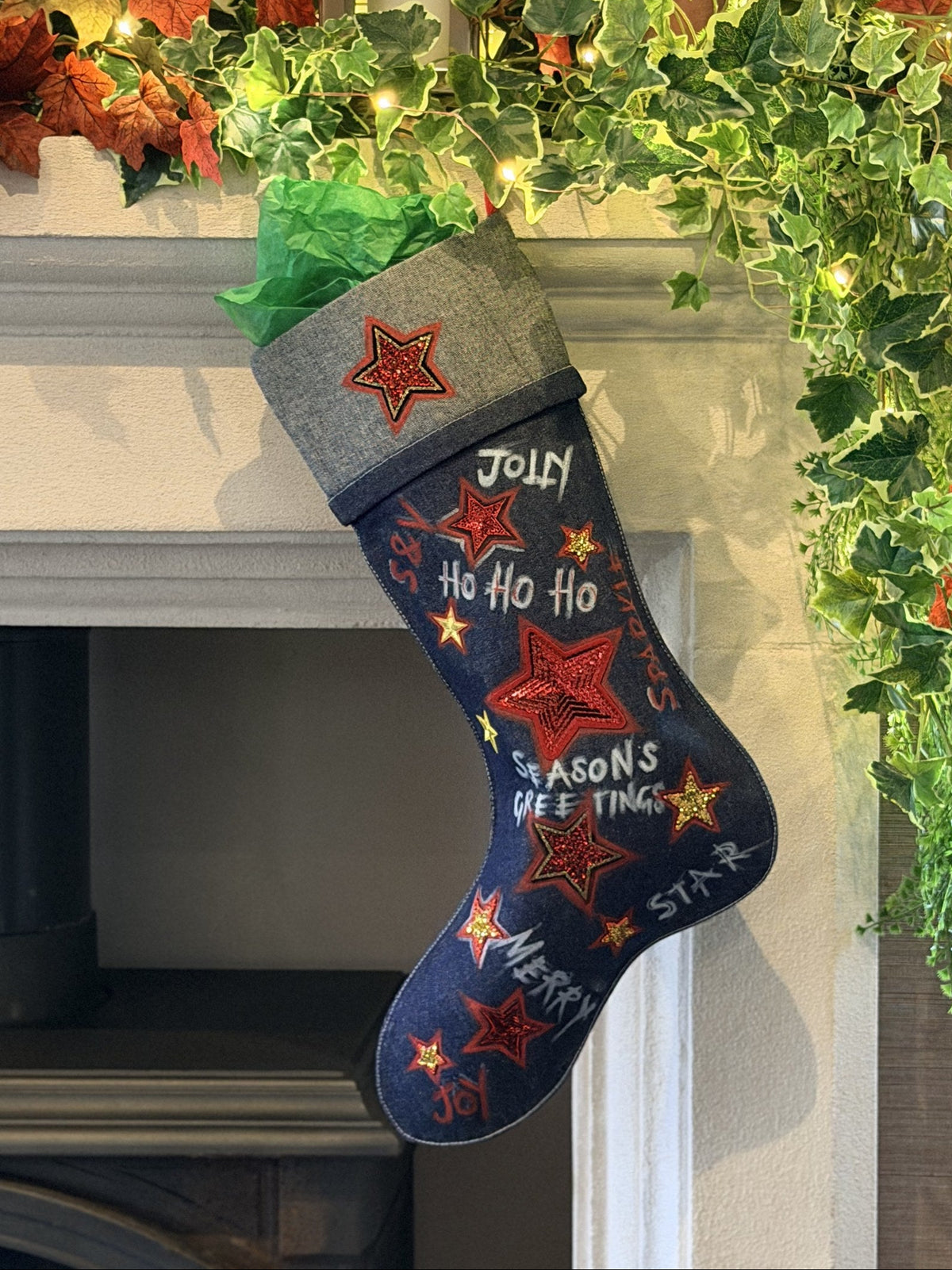 Jingle Bell Rock Denim Christmas Stocking, hanging on a fireplace