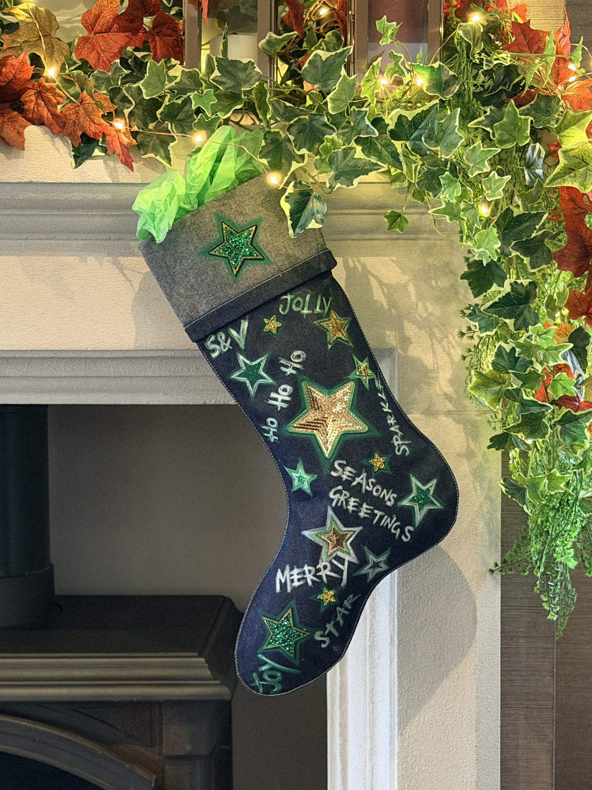 Holly Jolly Denim Christmas Stocking, hanging on a fireplace