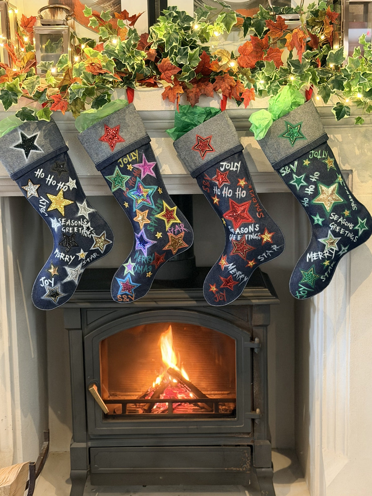 All four Skinner & Vale denim Christmas stockings hanging on a fireplace